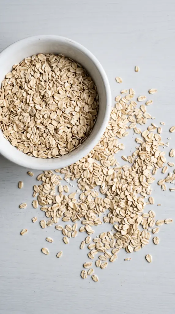 Rolled oats in a white bowl on a light grey table
